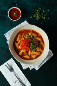 Sotelenmiş pirinç keki, özel Tteokbokki baharat karışımı, Kimchi lahana turşusu, noodle, susam ve yeşil soğan ile